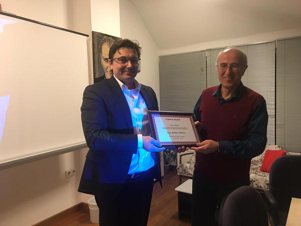 Tanju Karagoz, chapter secretary (l), presents the certificate of appreciation to guest speaker Mehmet Topcu at the chapter's April meeting.