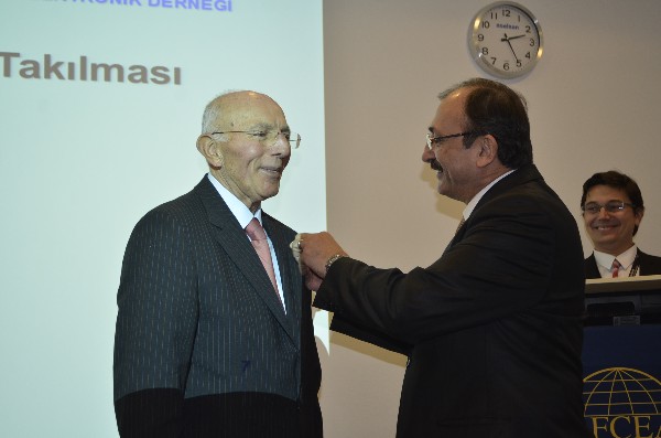 Chapter President Capt. K. Zafer Selcuk, TUN (Ret.), pins the Distinguished Life Member emblem to Col. Buyuhoner's lapel