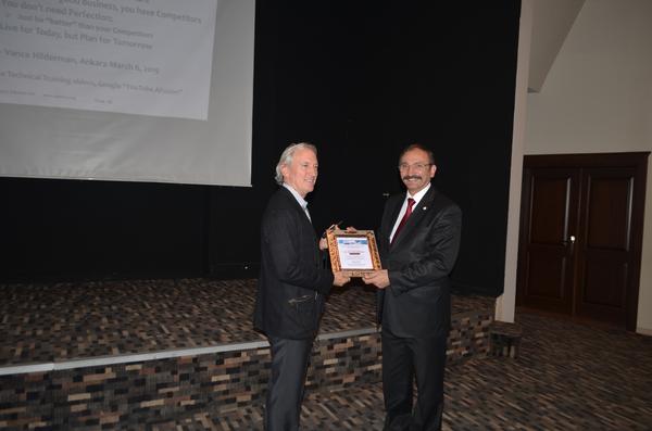 Chapter president Capt. Zafer Selcuk (Ret.) (r), presents a commemorative plaque to Vance Hilderman at the March meeting.