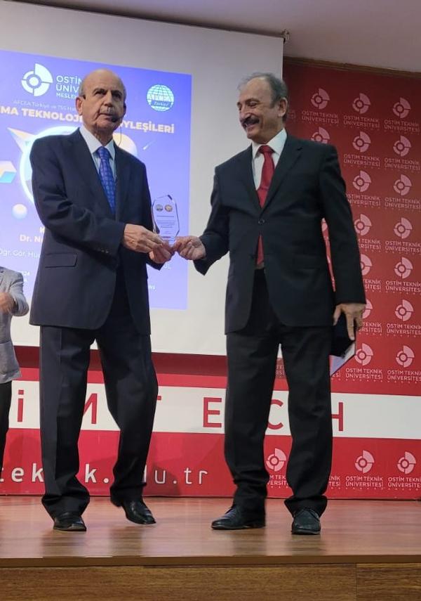 Chapter President Kamil Zafer Selçuk presents a commemorative plaque to Caglayan in October.