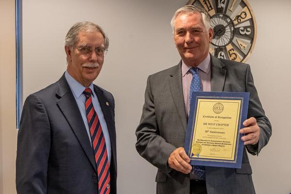 Chris Yorke, AFCEA regional vice president for Western Europe (l), presents the 30th Anniversary Certificate of Recognition to John Kirby, the outgoing chapter president. (photo - Collin Nash)
