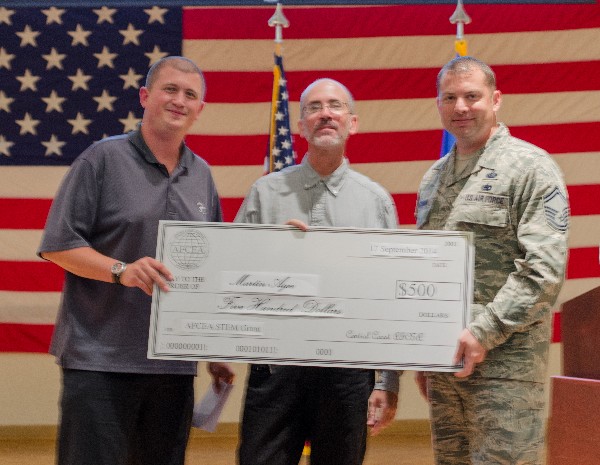 Nathan Simmons, chapter vice president, awards (l) and Senior Master Sgt. Patrick Hackman, USAF, chapter vice president, Young AFCEAN Affairs, present a science, technology, engineering and mathematics grant to Martin Agee, Vandenberg Middle School in September.