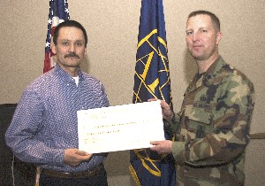 Col. Gullet (r), USAF, presents Larry Madrigal of Saint Joseph High School a $1,000 Science Teaching Tool Grant in February.