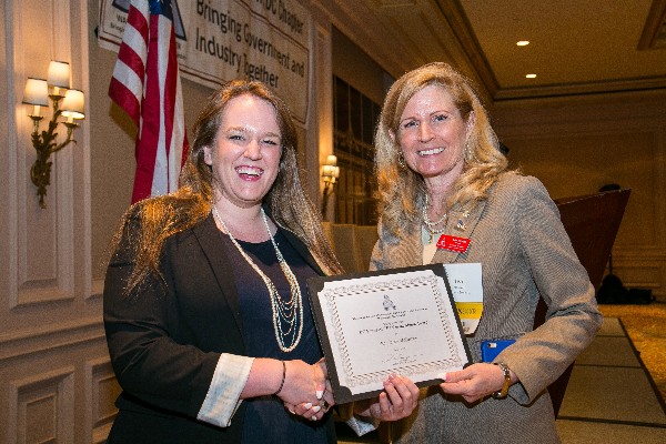 Casey McCarthy, capture manager with Kforce Government Solutions, receives the April Young AFCEAN of the Month certificate from Newell.