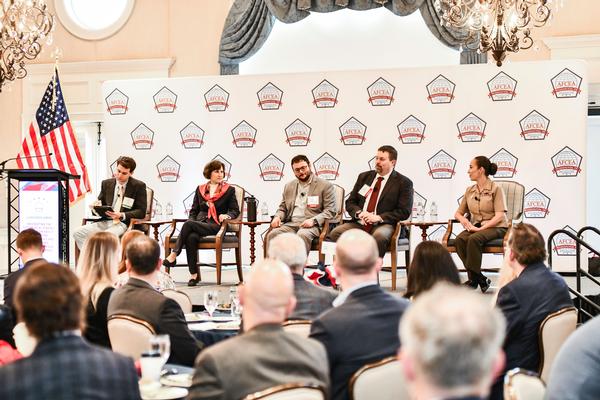 Panelists engage in lively discussion during the May luncheon.