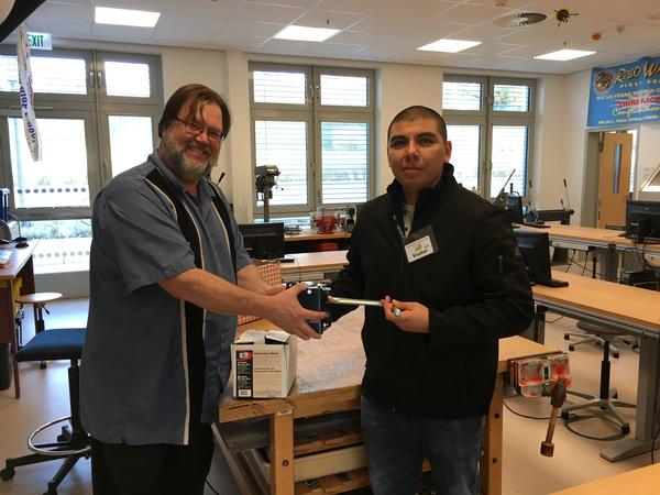 On behalf of the chapter, John Mosqueda, vice president of education and scholarships (r), donates two crank worm gear winches to Wiesbaden High School's STEM program in October for use in future engineering projects.