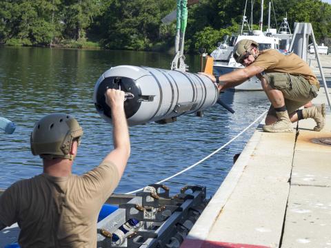 Sailors load an unmanned underwater vehicle onto an inflatable boat during a mine countermeasure certification exercise at Panama City, Florida. Credit: Mass Communication Specialist 2nd Class Charles Oki, U.S. Navy