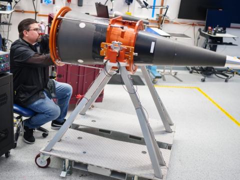 A scientist in April 2025 examines a development cone of the W87-1, the advanced nuclear warhead in development. As lead systems integrator, Sandia National Laboratories’ role in nuclear weaponry spans the entire lifespan of the weapon and requires close collaboration with other labs, plants and sites. Credit: Sandia photo by Craig Fritz
