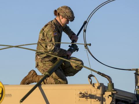 A soldier attaches long-range radio equipment to a Humvee. A GAO report warns that adversaries could take control of the electromagnetic spectrum in the battlespace if the Defense Department doesn't establish effective plans and oversight of its EMS efforts. Credit: U.S. Air Force photo