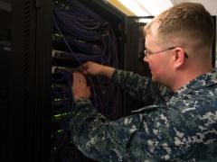 U.S. Navy Petty Officer 1st Class William Croninworks works on network infrastructure. Photo by Maj. Jon Quinlan.