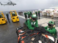 Sailors loosen the netting on a supply pallet aboard the aircraft carrier USS George Washington during a vertical replenishment with the Military Sealift Command. Credit: Petty Officer 3rd Class Jared Hill, U.S. Navy