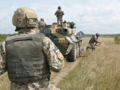 A Ukrainian Observer Coach Trainer looks on as soldiers from Ukraine’s 1st Battalion, 95th Separate Airmobile Brigade dismount their BTR-3 armored personnel carrier during combined mounted and dismounted movement techniques training at the Yavoriv Combat Training Center on the International Peacekeeping and Security Center near Yavoriv, Ukraine on Aug. 21, 2017. Photo by 1st Lt. Kayla Christopher, 45th Infantry Brigade Combat Team.