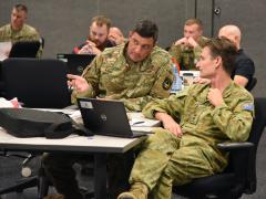 Col. Jackie Kaina of Army Futures Command (l) speaks to Lt. Col. Stuart Purves of the Australian army during a working group session June 7, 2022, during the Project Convergence 22 final planning conference on Fort Bliss, Texas. Army Cyber Command wants computing architectures proven to work in contested environments as well as technology, offering greater visibility into cloud computing environments. Photo by Jonathan Koester 