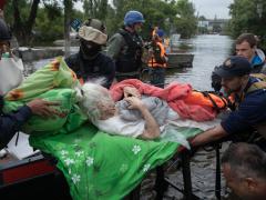 Lifeguards and volunteers evacuate an elderly woman in Kherson, Ukraine, after the Kakhovka Dam was allegedly destroyed by Russian occupying forces in June, causing floods. Credit: Drop of Light/Shutterstock