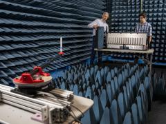 Ryan Westafer (l) and Alex Saad-Falcon, co-lead investigators for the Tensors for Reprogrammable Intelligent Array Demonstrations (TRIAD) program at the Georgia Tech Research Institute, offer a final demonstration setup of the transmitting antenna in the foreground on a metal arm attached to a turntable and the elemental digital array in the background. Credit: Sean McNeil, GTRI