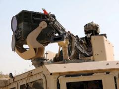 A U.S. Army soldier watches over tanks in his unit with a Long Range Scout Surveillance System equipped with a third-generation forward-looking infrared technology at the National Training Center, Fort Irwin, California.