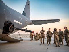 A U.S. Air Force combat systems officer from the 73rd Special Operations Squadron showcases a 105 mm cannon on an AC-130J Ghostrider to other U.S. service members at Al Udeid Air Base, Qatar, June 28, 2023. The U.S. Central Command, whose area of responsibility is the Middle East, is employing large language models, a type of artificial intelligence, to some of its processes. U.S. Air Force photo by Senior Airman Leon Redfern