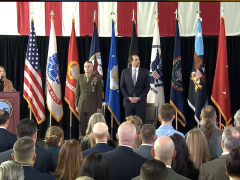 A defense official begins the ceremony for Lt. Gen. James Adams, USMC, (c) to become the director of the Defense Intelligence Agency, with Bradley Hansell, the undersecretary for Intelligence and Security, laying out the department's priorities for the agency.