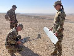 U.S. Army Sgt. 1st Class Jay Utter (kneeling), HHC 1-163rd Combined Arms Battalion, repairs an unmanned aerial vehicle (UAV) with Italian Air Force Warrant Officer Paolo Robles, commander of a counter-UAV team with the 16th Force Protection Wing of the Italian Air Force, and U.S. Army Capt. Olivia Cobiskey, as part of Exercise Eager Lion 22, in September 2022.  U.S. Army photo by Cpt. Olivia Cobiskey