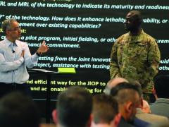 The U.S. Army Capability Program Executive Simulation, Training, Test and Threat’s chief technology officer, Marwane Bahbaz (l), speaks to Col. Peter Amara, assistant director to the deputy assistant secretary of the Army for Data, Engineering and Software and industry representatives during a Technical Exchange/Industry Day in March at the Central Florida Tech Grove in Orlando, Florida. U.S. Army photo by Donnie Ryan