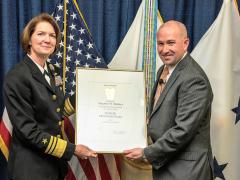 DISA Director Vice Adm. Nancy A. Norton, USN, presents Steve Wallace with his promotion certificate as he takes over the agency’s newly created Emerging Technology (EM) Directorate.
