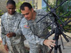 Army soldiers check the setup up of an antenna for voice and data tactical communications in Port-au-Prince, Haiti. While the responsibilities between the Cyber and Signal branches are still evolving, a seven-layer model may be helpful in defining the divide. U.S. Navy photo by Chief Petty Officer Robert J. Fluegel