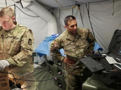 Maj. Ian Cassaday, USA (l), a surgeon with the 250th Forward Surgical Team, utilizes a Telehealth in a Bag kit and a GlobalMed TES to simulate a craniotomy performed by a non-neurosurgeon during testing of virtual health capabilities in the field. U.S. Army