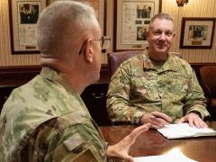 Brig. Gen. Robert Lyman (USAF), director, Command, Control, Communications, and Cyber Systems Directorate, TCJ6, pictured center, speaks to Col. Mark Bradley, USAF, the TCJ6 deputy director at the U.S. Transportation Command (USTRANSCOM) on June 9. In July, Gen. Lyman will be joining the Pentagon as the Air Force’s assistant deputy chief of staff for Cyber Effects Operations, AF A2/A6. Photo by Michelle Gigante, USTRANSCOM/PA
