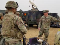 Capt. Zachary Schofield (center), USA, assistant product manager with Wideband Enterprise Satellite Systems, demonstrates an inflatable satellite antenna (ISA) to soldiers at Camp Humphreys, South Korea in 2019. The Army’s Communications Electronics Command (CECOM) has a global support program in place to ensure communications equipment readiness. Credit: Amburr Reese, CECOM Public Affairs