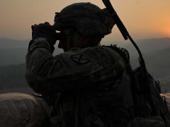 A U.S. Army staff sergeant observes the area around Forward Operating Base Torkham, Afghanistan, while wearing a new communications suite. The Communications and Human Networks program strives to improve mobile ad hoc networking for future warfighters.