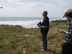 On the beaches at Camp Pendleton, Cory Stephanson, president and CEO, Broadband Discovery Systems Inc., launches a sensor-laden drone that collects data about buried mine materials while Dr. Rosemarie Oelrich, scientist, Naval Surface Warfare Center Carderock, monitors the information on a handheld Android device.