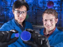 Sandia National Laboratories researcher Patrick Feng (l), holds a trans-stilbene scintillator and organic chemist Joey Carlson holds a scintillator made of organic glass.