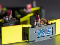 Close-up of a "smarticle"—smart active particle—showing the two 3D-printed arms, light sensor and motor. Credit: Rob Felt, Georgia Tech