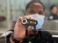 A U.S. Customs and Border Protection Officer at Dulles International Airport in Virginia holds up a camera used for facial biometric process. The agency is deploying biometric identity solutions to six more international airports in the southern United States. Credit: CBP