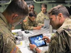 Maj. Matthew Bailey, USA, executive officer, 3rd Squadron, 2d Cavalry Regiment (3/2CR), and 1st Lt. Trevor Rubel, USA, battle captain for the tactical command post, 3/2CR, review an operational overlay on a Nett Warrior device in preparation for an airfield seizure during the NATO Saber Strike 18 exercise in Kazlu Ruda, Lithuania. U.S. Army photo by 1st Lt. Joshua Snell