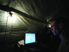 A U.S. Air Force network administrator employs a laptop at Kandahar Airfield, Afghanistan.