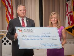 Lt. Gen. Robert M. Shea, USMC (Ret.), president and CEO of AFCEA International, accepts a check from Susan Lepera, former president of the Central Maryland Chapter, for the AFCEA Educational Foundation.