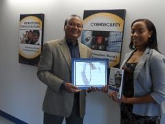 Mansur Hasib, chair of the graduate cybersecurity technology program at the University of Maryland, Baltimore County, presents the 2015 AFCEA STEM Major Scholarship for Diversity Students to Kiara Jones, a graduate.