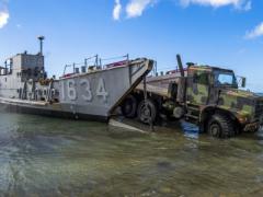 A U.S. Army light medium tactical vehicle departs for the beachfront from a U.S. Naval Landing Craft Utility operating out of the USS Ashland (LSD 48) providing typhoon relief on Saipan, Commonwealth of the Northern Mariana Islands in November 2018. With military activity worldwide, the Army Contracting Command has to meet global demands.  U.S. Air Force photo by Tech. Sgt. Christopher Ruano