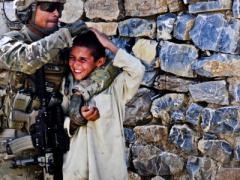 A U.S. Army soldier gives a playful head rub to a to a local boy while on patrol near Forward Operating Base Salerno in Afghanistan. Human intuition may one day help artificial intelligence distinguish between safe and dangerous scenarios.