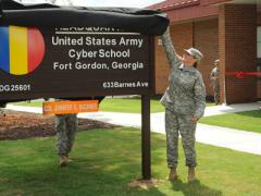 Maj. Gen. LaWarren Patterson, USA, the U.S. Army Cyber Center of Excellence and Fort Gordon commander, and Col. Jennifer Buckner, USA, Army Cyber School commandant, unveil a sign during a ribbon-cutting ceremony for the school.