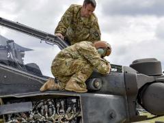 Soldiers conduct preventive maintenance checks on an AH-64D Apache Longbow helicopter during training at the Grafenwoehr Training Area in Germany. Army photo by Spc. Nathanael Mercado