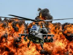 An AH-64D Apache attack helicopter flies in front of a wall of fire during the South Carolina National Guard Air and Ground Expo at McEntire Joint National Guard Base, South Carolina, in 2017. Air National Guard photo by Tech. Sgt. Jorge Intriago