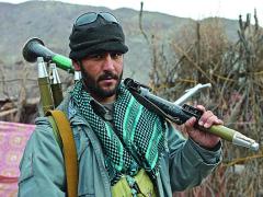 An Afghan Uniform Police officer provides security with a rocket-propelled grenade launcher while U.S. Army medics attend to patients at the Azrah district clinic in Logar province, Afghanistan. Artificial intelligence may one day identify rocket propelled grenades and other weapon systems.