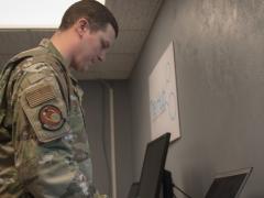Staff Sgt. Jonathan Witzel, USAF, inspects a customer's laptop on Barksdale Air Force Base, Louisiana on March 20. With the COVID-19 pandemic forcing many Defense Department personnel to work from home, the Defense Information Systems Agency is seeing increased demand for its Cloud-Based Internet Isolation technology. U.S. Air Force photo by Tech. Sgt. Daniel Martinez