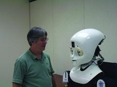 LASR director Alan Schultz engages one of the lab's humanoid robots in the Prototyping High Bay.