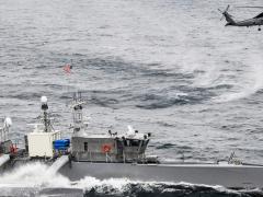 A Seahawk unmanned surface vessel in the Pacific Ocean and an MH-60R Sea Hawk helicopter from the Helicopter Maritime Strike Squadron 73 participate in U.S. Pacific Fleet’s Unmanned Systems Integrated Battle Problem 21 in April. Naval exercises have been crucial to aiding the integration of unmanned vessels into the fleet and pairing with manned capabilities, experts say. Credit: U.S. Navy/Chief Mass Communication Specialist Shannon Renfroe