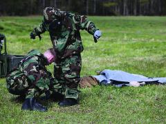 Marines at Camp Lejeune, North Carolina, assist each other in donning chemical and biological protection suits. Scientists are working to develop new fabrics that will minimize the need for the heavy, uncomfortable suits.