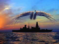 HMS Dragon’s Lynx helicopter fires infrared flares during an exercise over the Type 45 destroyer.
