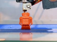 An automatic 3D printer creates a small robot figure on an additive manufacturing platform. The technology is ideally suited for custom manufacture of small parts and items. Shutterstock/Kyrylo Glivin